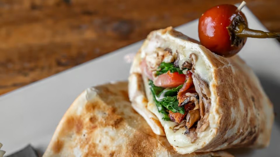 A panini and roasted vegetables plated at Panino's North Oaks